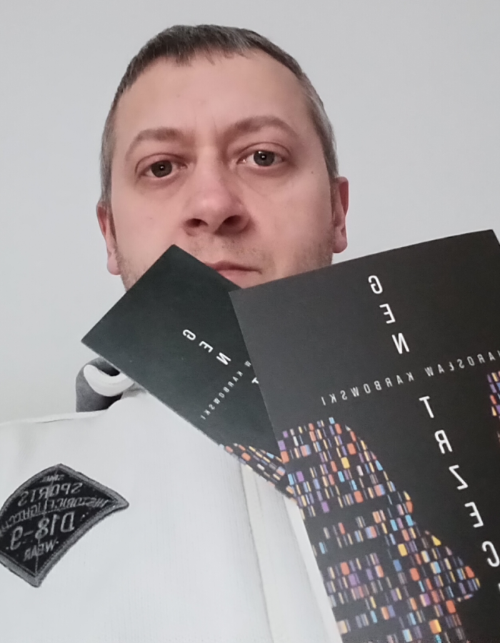 Mężczyzna trzymający dwie książki z napisem "Technologie sieci" i "e.M".